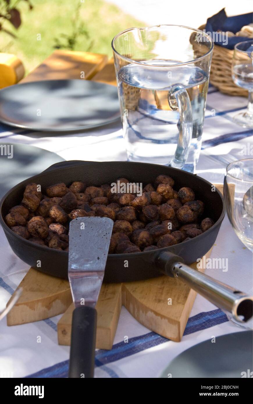 Bratpfanne mit schwedischen Fleischbällchen auf dem Tisch draußen in der Sommersonne - Stockfoto