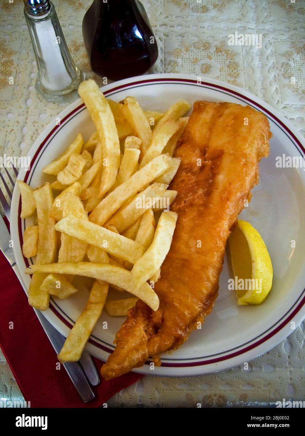Klassischer britischer Fish and Chips auf dem Tisch in einem typischen Restaurant. - Stockfoto