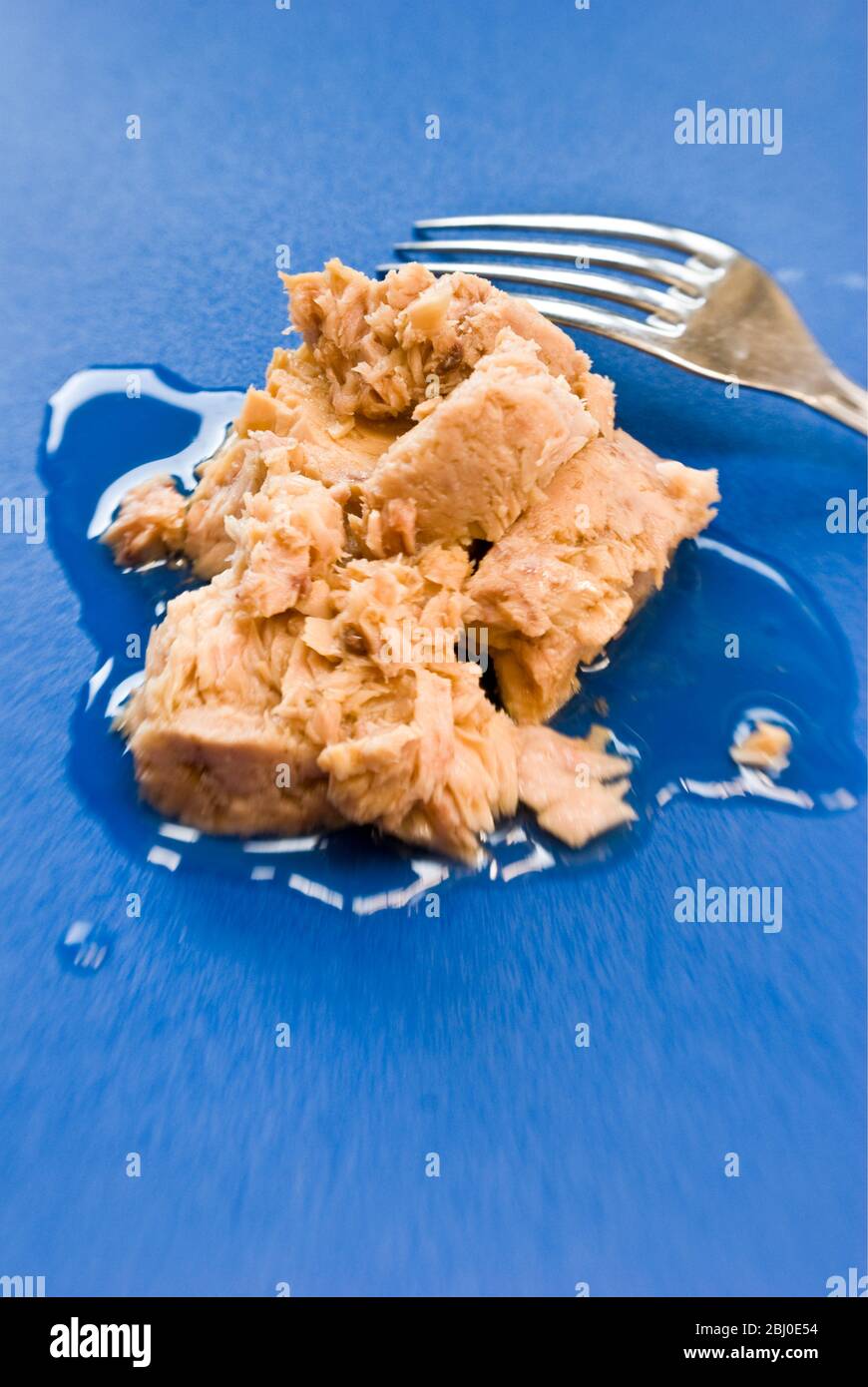 Thunfisch in Olivenöl in der Dose wurde auf blaue Oberfläche - Stockfoto