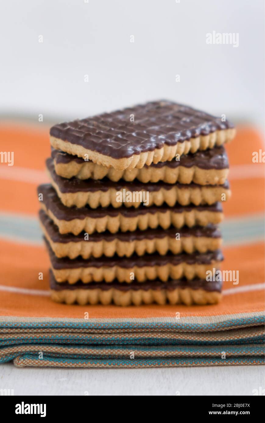 Stapel von Schokolade Ingwer Kekse auf orangefarbener Serviette - Stockfoto