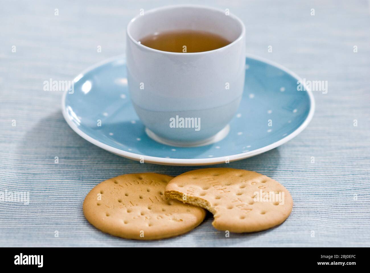 Zwei reichhaltige Teegebäck und eine Tasse grüner Tee als entspannende Pause - Stockfoto