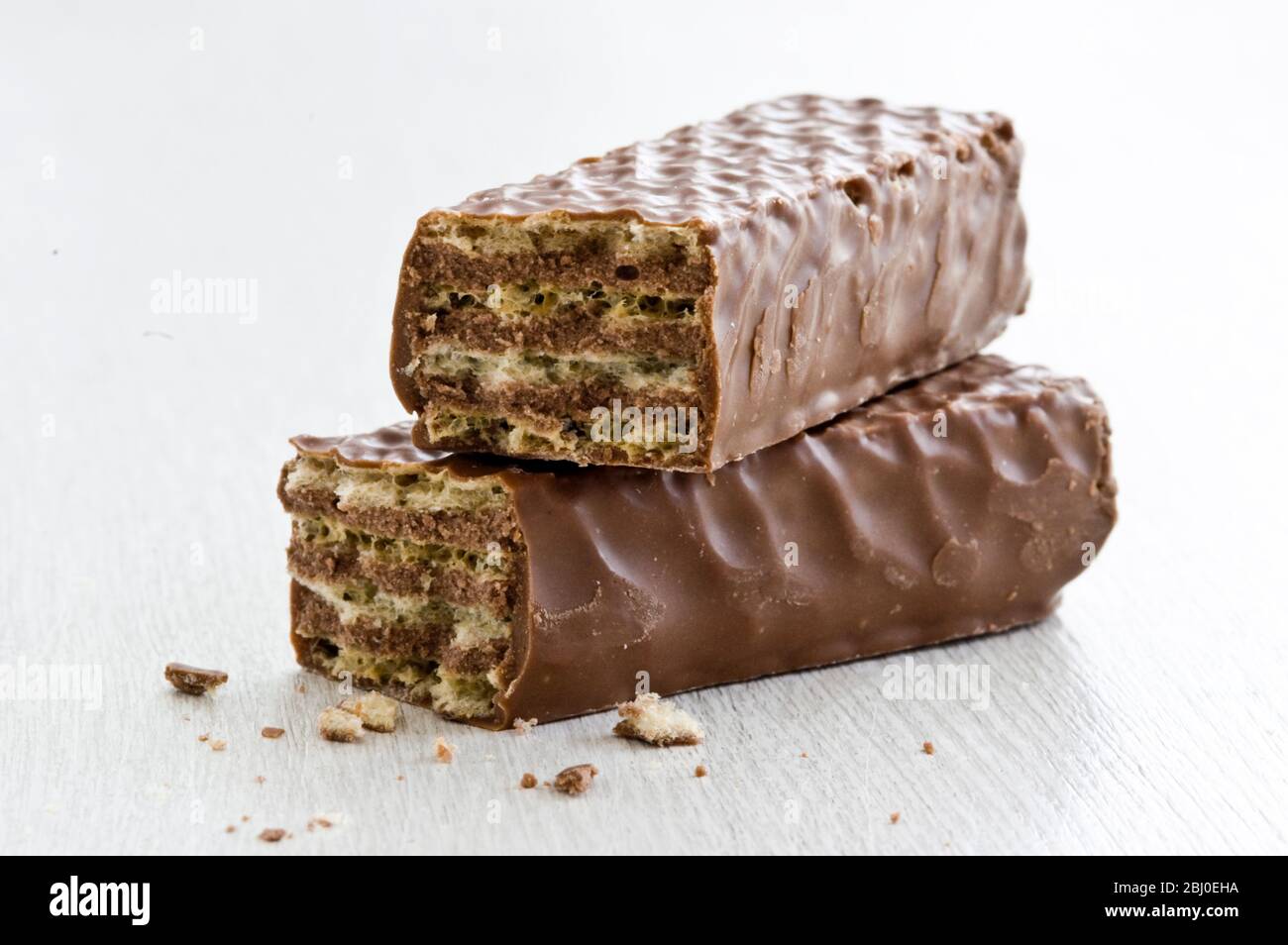Schokoladen-Waffelstange, in zwei Teile gebrochen, auf weißer Oberfläche. - Stockfoto