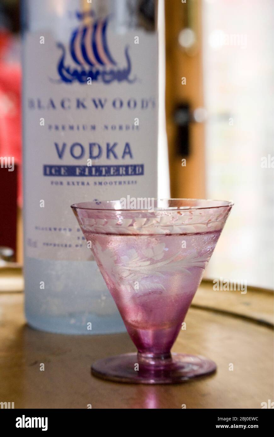 Kleines dekoratives Glas Wodka auf den Felsen, auf Blattgoldtablett, mit Flasche Blackwood Shetland chill-filtrierten Wodka - Stockfoto