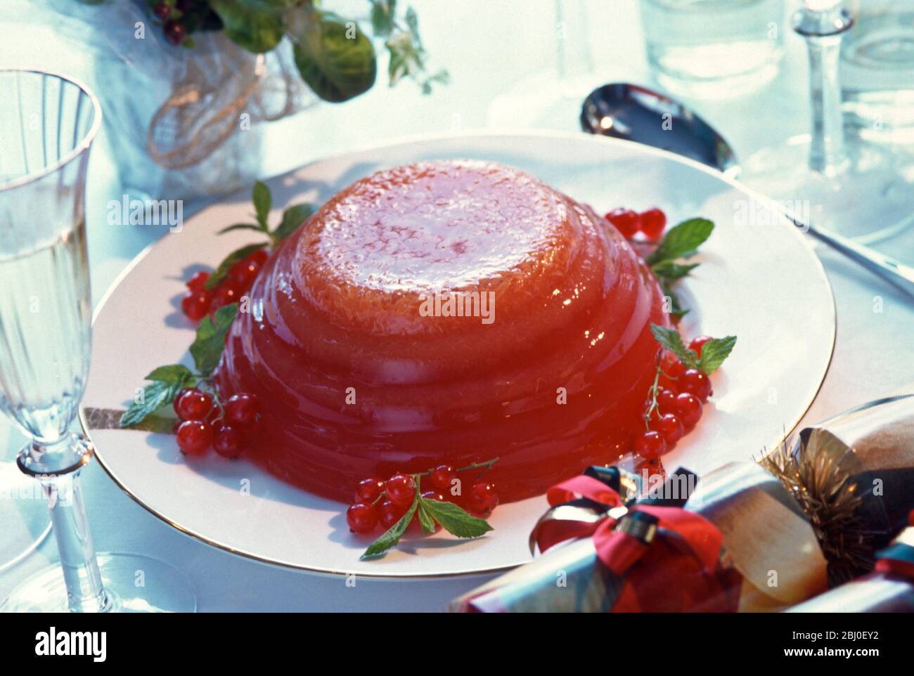 Alternative Weihnachts-Dessert - Gelee (Jello) von roten Beeren in geriffelte Schüssel gesetzt und mit roten Johannisbeeren verziert - Stockfoto