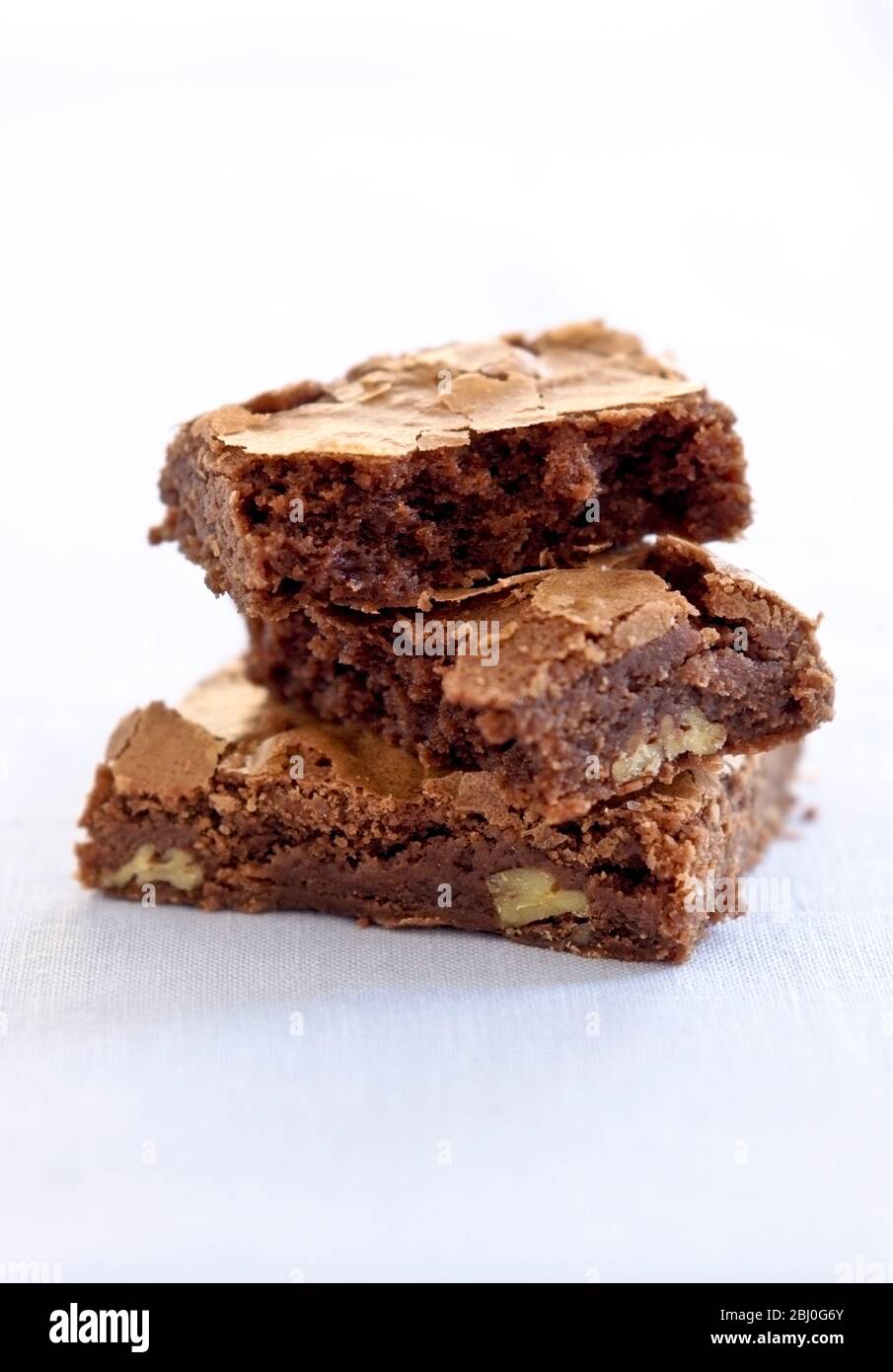Drei Schokoladenbrownies auf weißem Hintergrund gestapelt - Stockfoto
