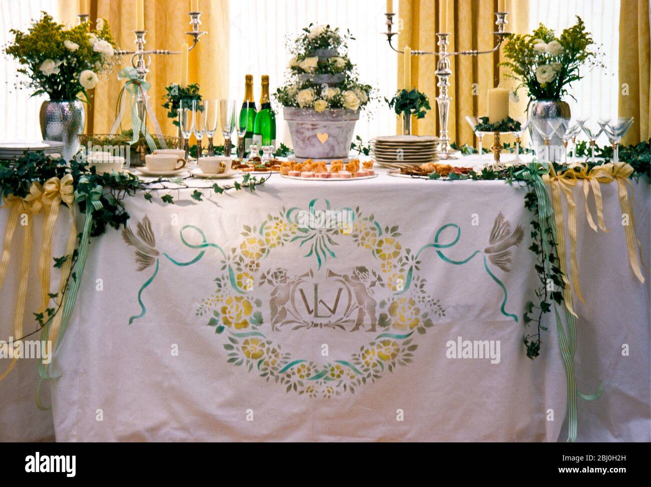 Hochzeitstisch, mit bedrucktem Design, Efeu-Tüchern und Blumenschmuck - Stockfoto