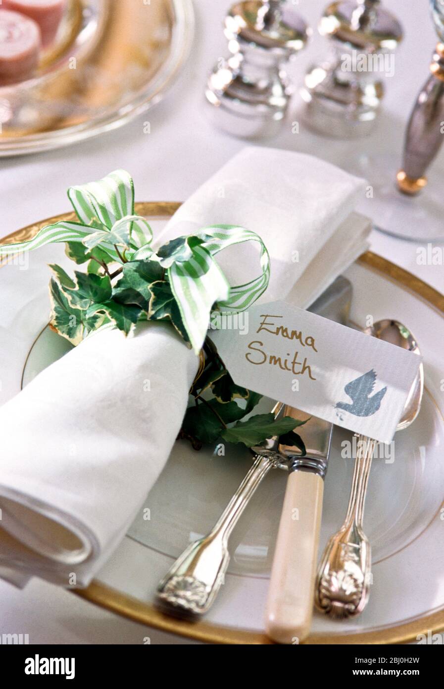 Hochzeitsplatz Einstellung mit Serviette gebunden in grün gestreiftes Band und Efeu. - Stockfoto
