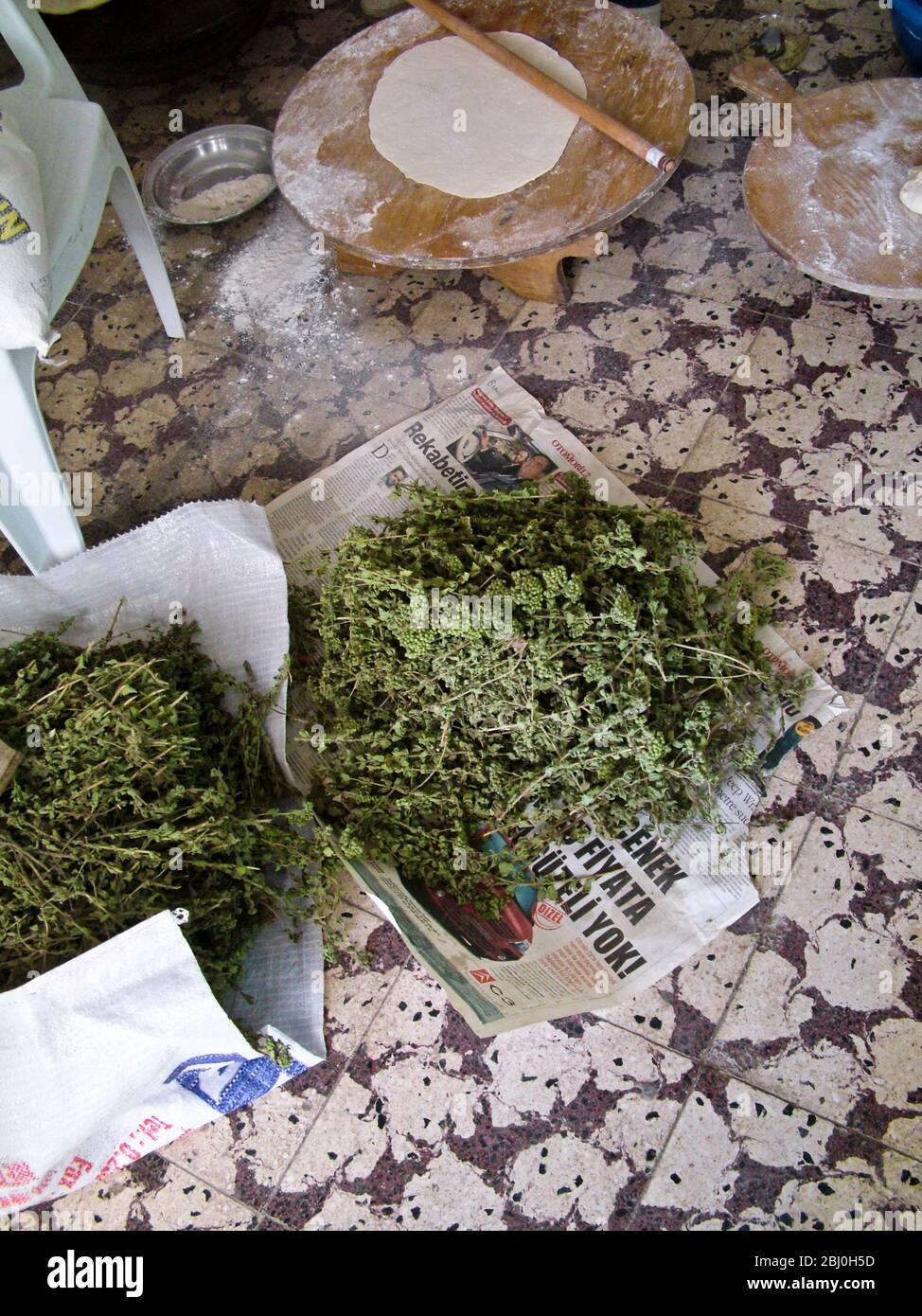 Großer dünner Kreis des Brotes auf einem runden Holzbrett auf dem Boden der Bäckerei am Kai. Hinter ist die Gas-Heizplatte verwendet sie, um das Brot zu backen, und in Fr. Stockfoto