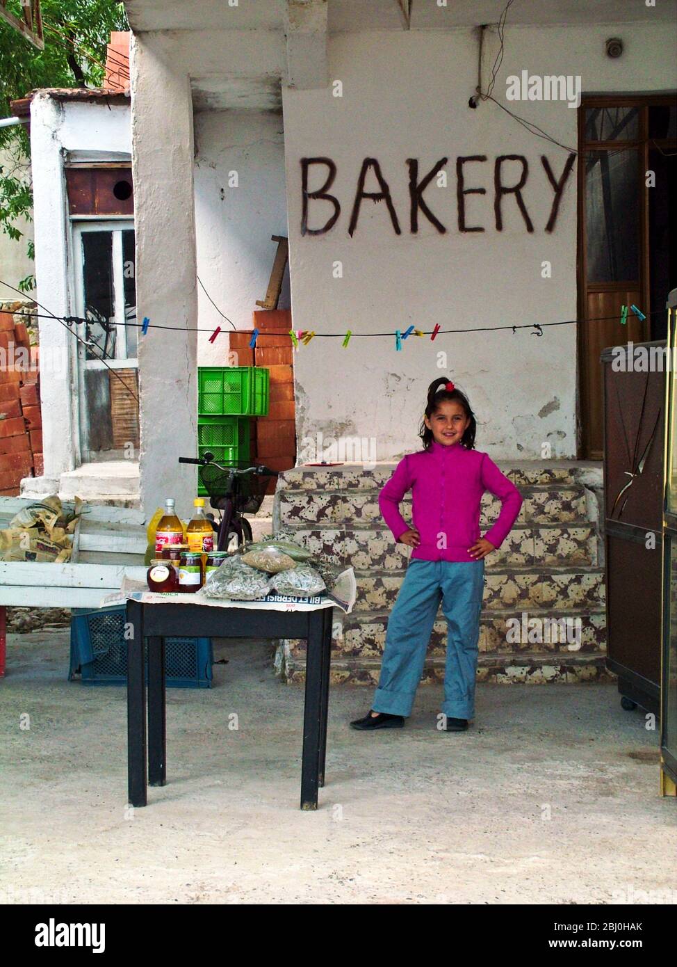 Kleines Mädchen bei der Bäckerei am Kai in Selimiye, an der Südküste Anatoliens, Türkei - Stockfoto