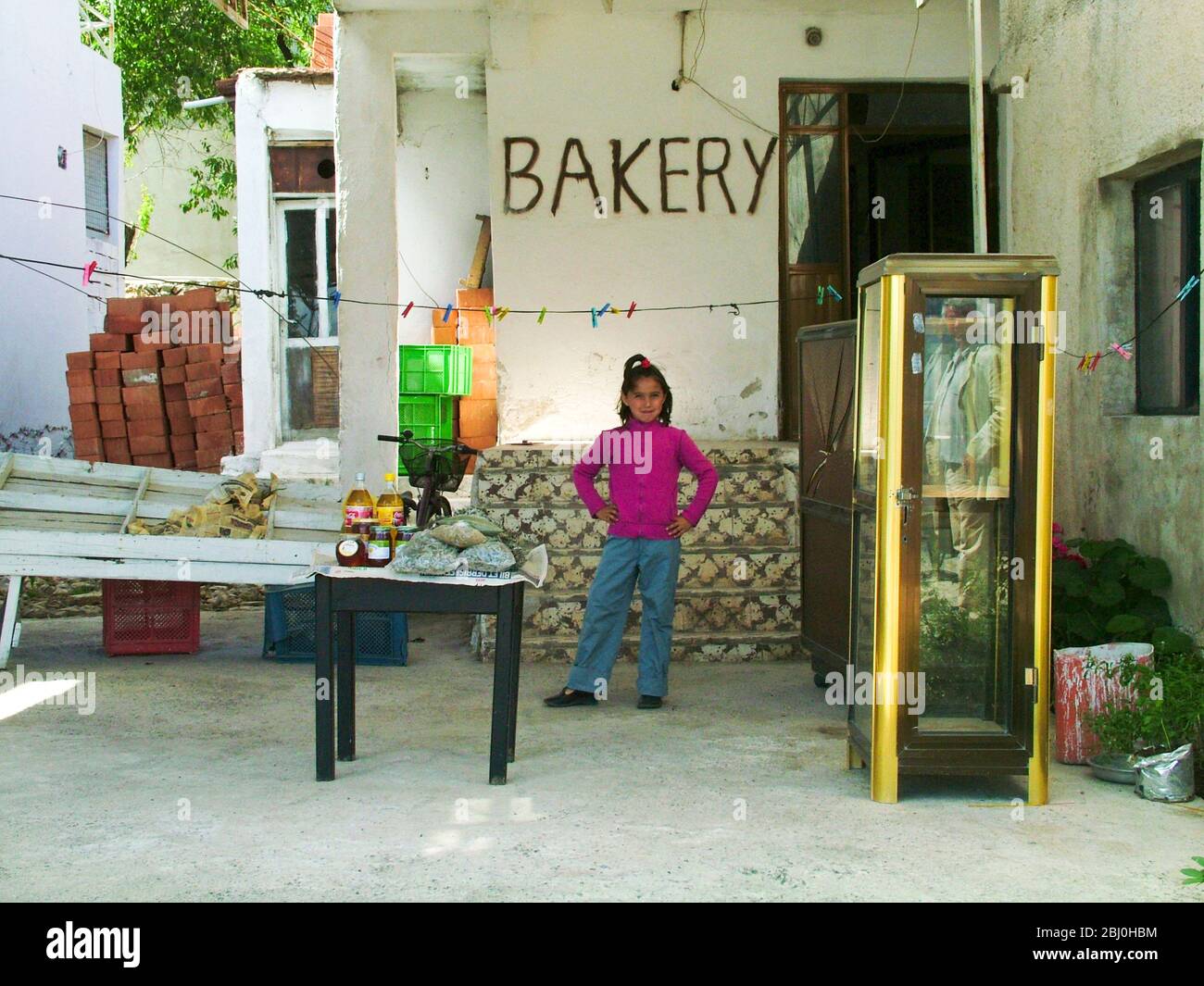 Kleines Mädchen bei der Bäckerei am Kai in Selimiye, an der Südküste Anatoliens, Türkei - Stockfoto