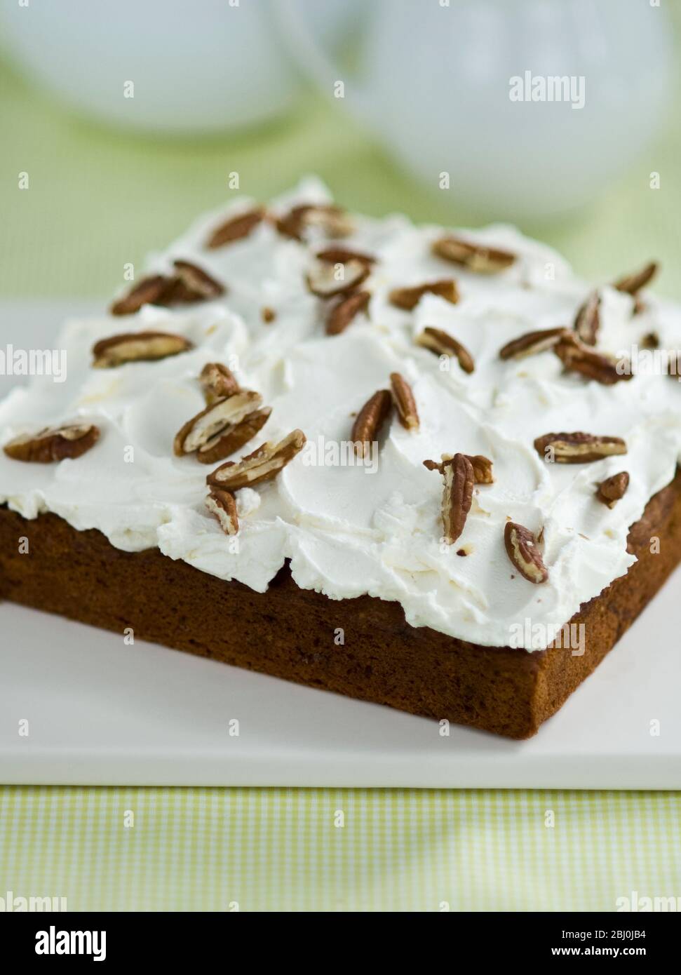 Passionstorte mit Buttercreme, die mit Pekannüssen-Splittern zerreißt - Stockfoto