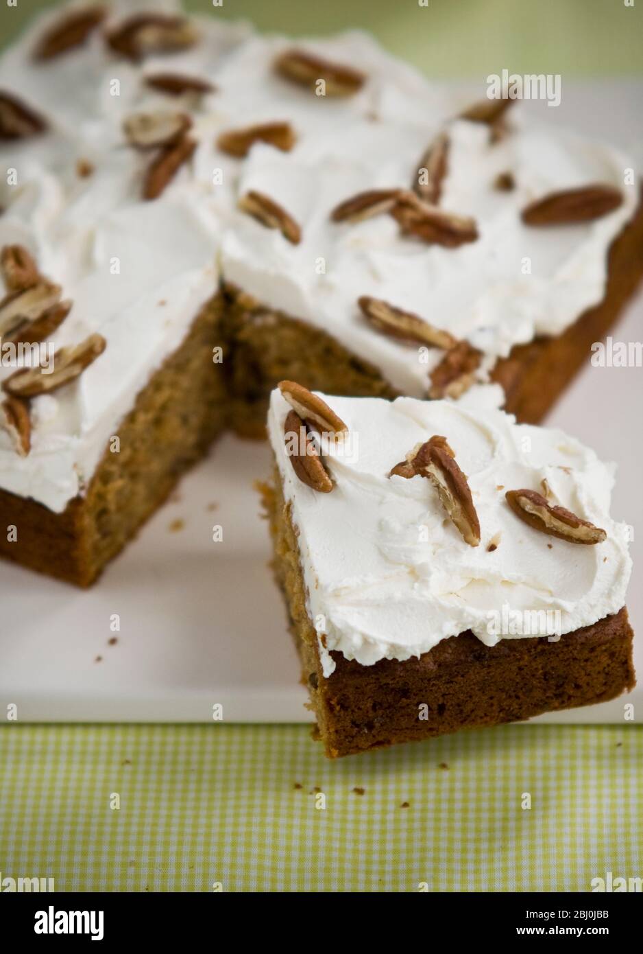 Passionstorte mit Buttercreme, die mit Pekannüssen-Splittern zerreißt - Stockfoto