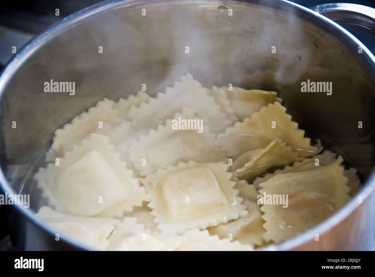 Ravioli in kochendem Wasser in Edelstahlpfanne gekocht Stockfoto