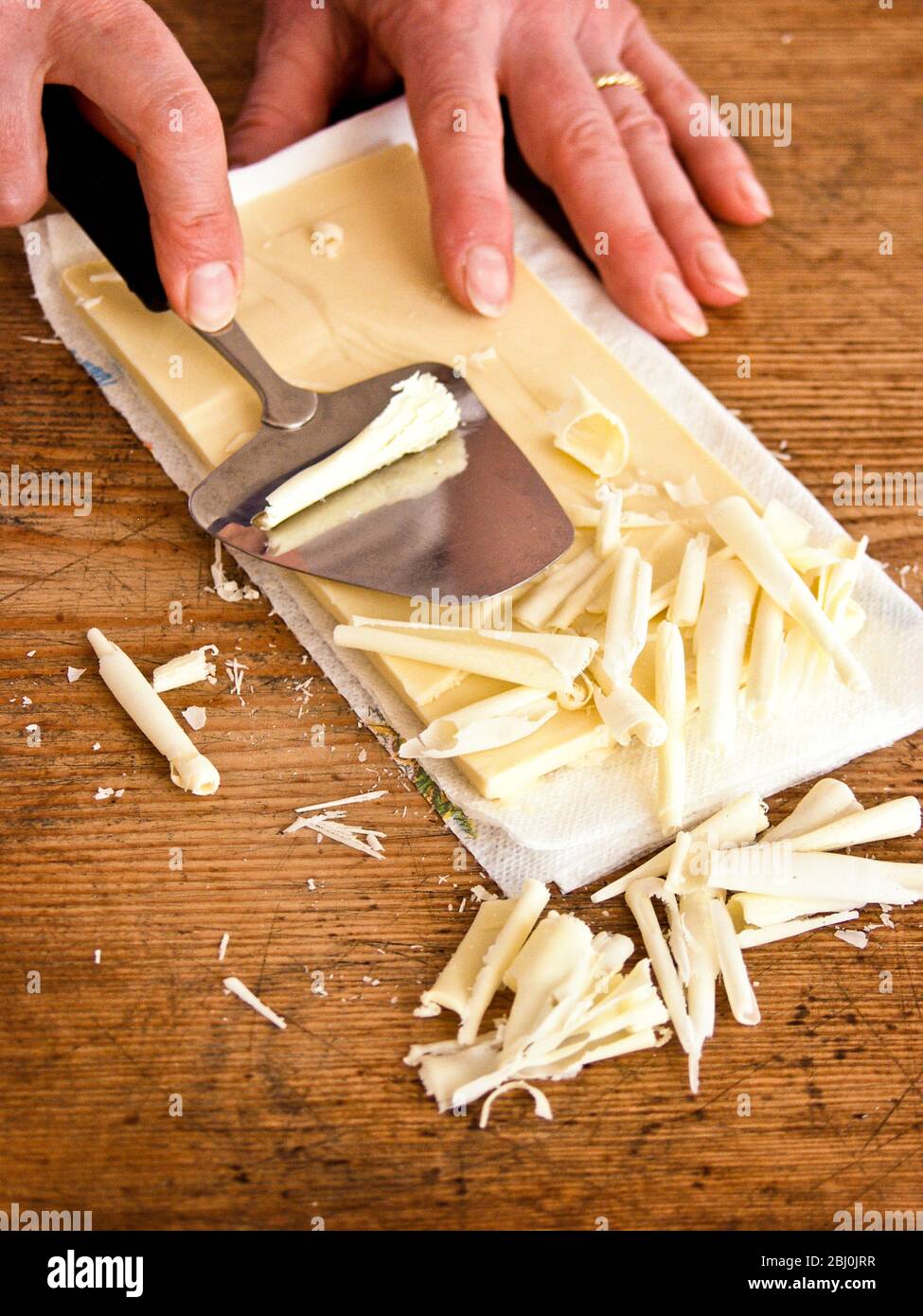 Herstellung von weißen Schokoladen-Locken aus Schokolade auf Marmorplatte - Stockfoto