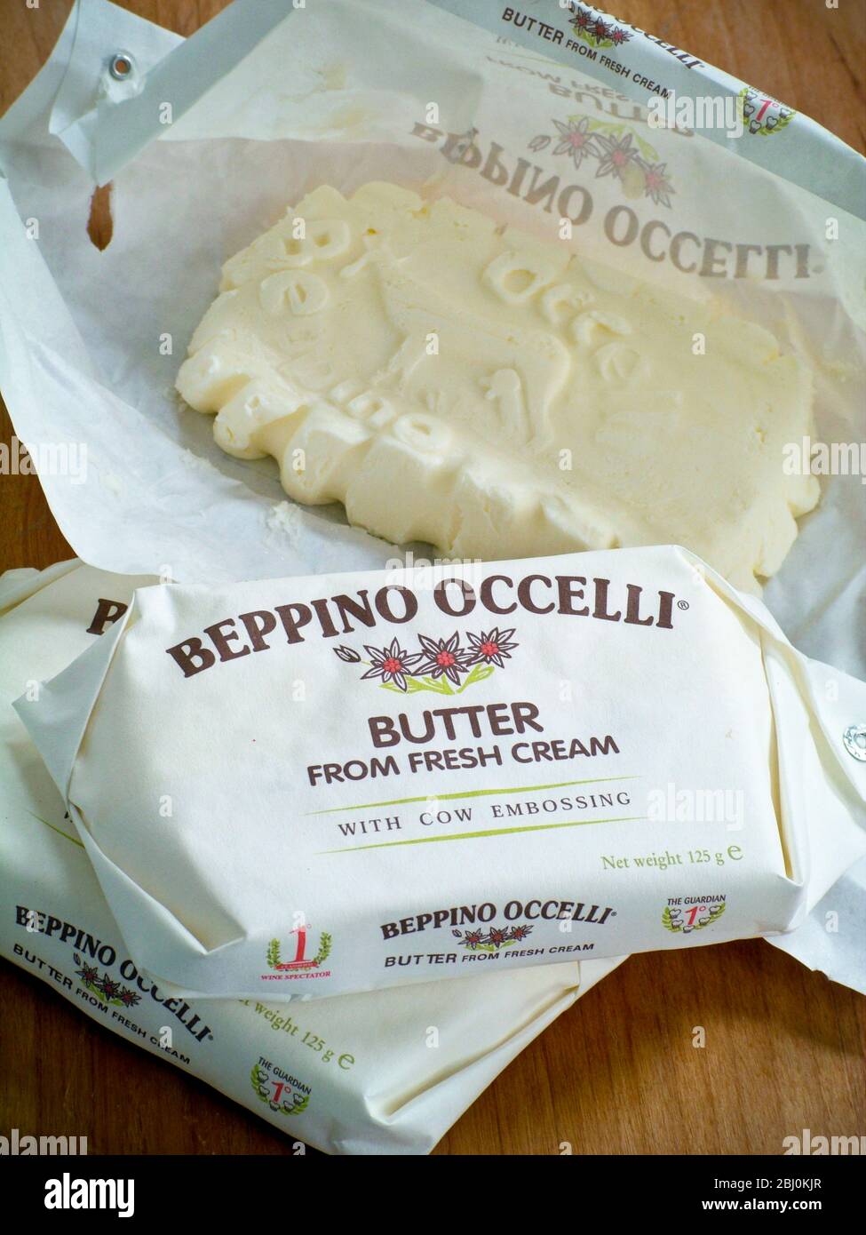 Beppino Occelli Italienische Butter in und aus der Verpackung gezeigt und zeigt die Reliefpaterne der geprägten Kuh. - Stockfoto