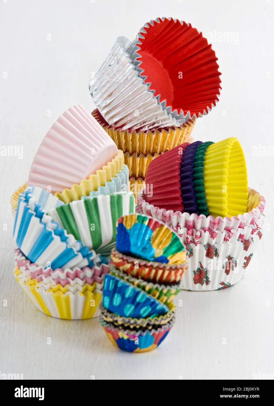 Stapel von dekorativen Papier- und Folienkuchen- und Muffin-Fällen - Stockfoto