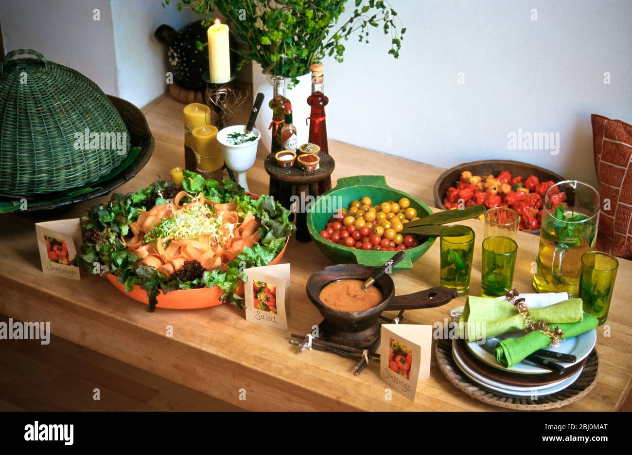 Karotten-, Pfeffer- und Tomatensalate in hellen Schüsseln und Körben für eine Mittagsbuffet-Party - Stockfoto