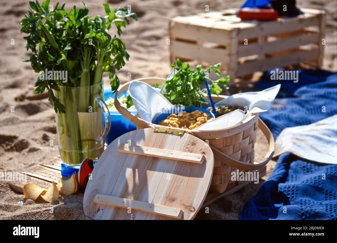 Strandpicknick mit Salaten in Schalen und Körben - Stockfoto