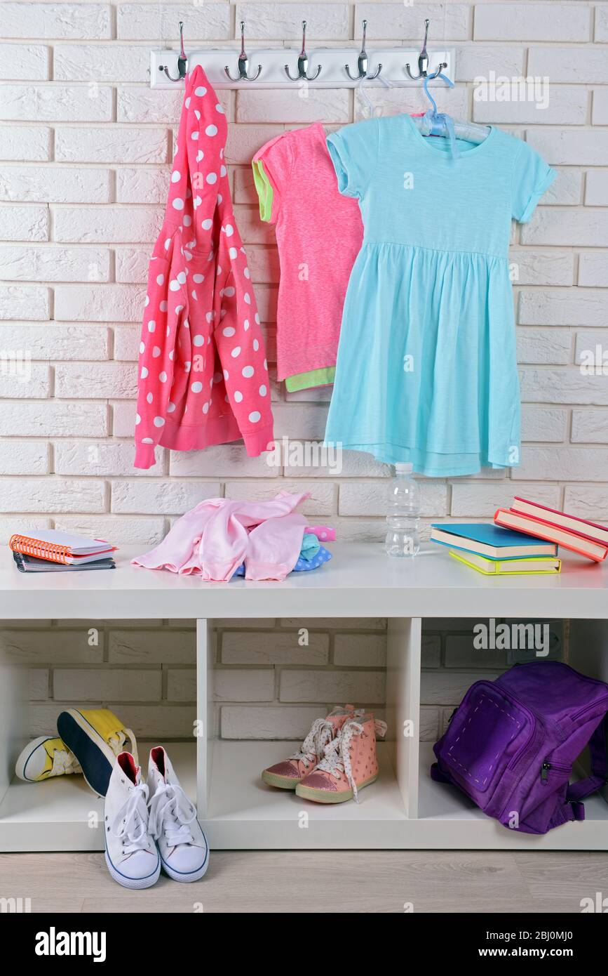 Kindersachen hängen an der Wand und stapeln sich im Zimmer Stockfoto