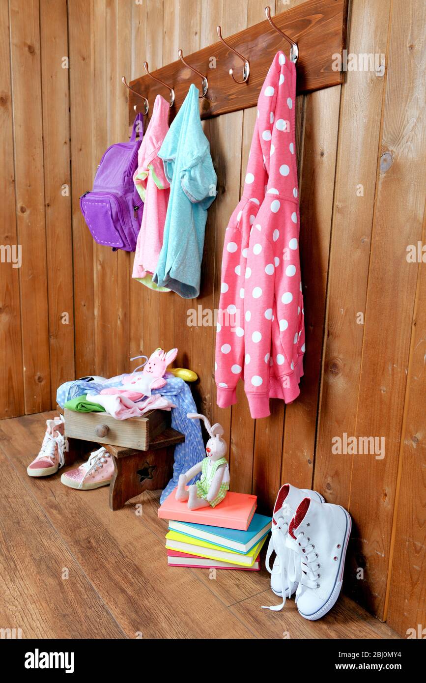 Kindersachen hängen an der Wand und stapeln sich im Zimmer Stockfoto