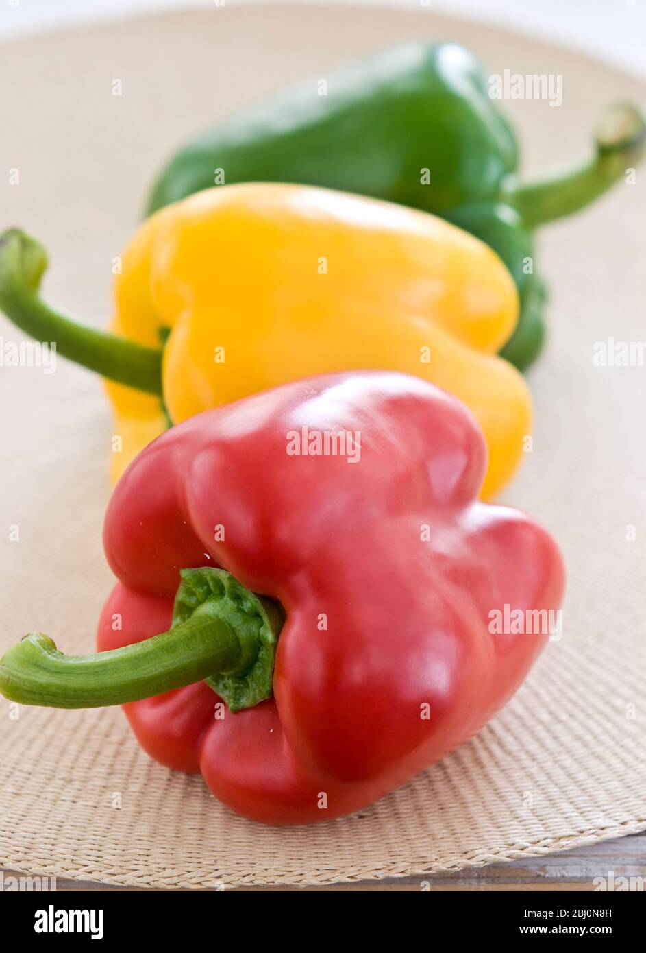 Drei glänzende Paprika, rot, grün und gelb - Stockfoto