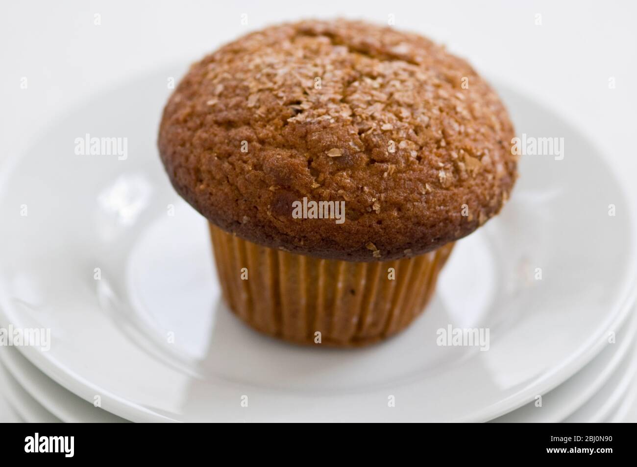 Zimtschnecken-Kleie Muffin auf weißen Tellern mit einer Tasse schwarzen Kaffee - Stockfoto