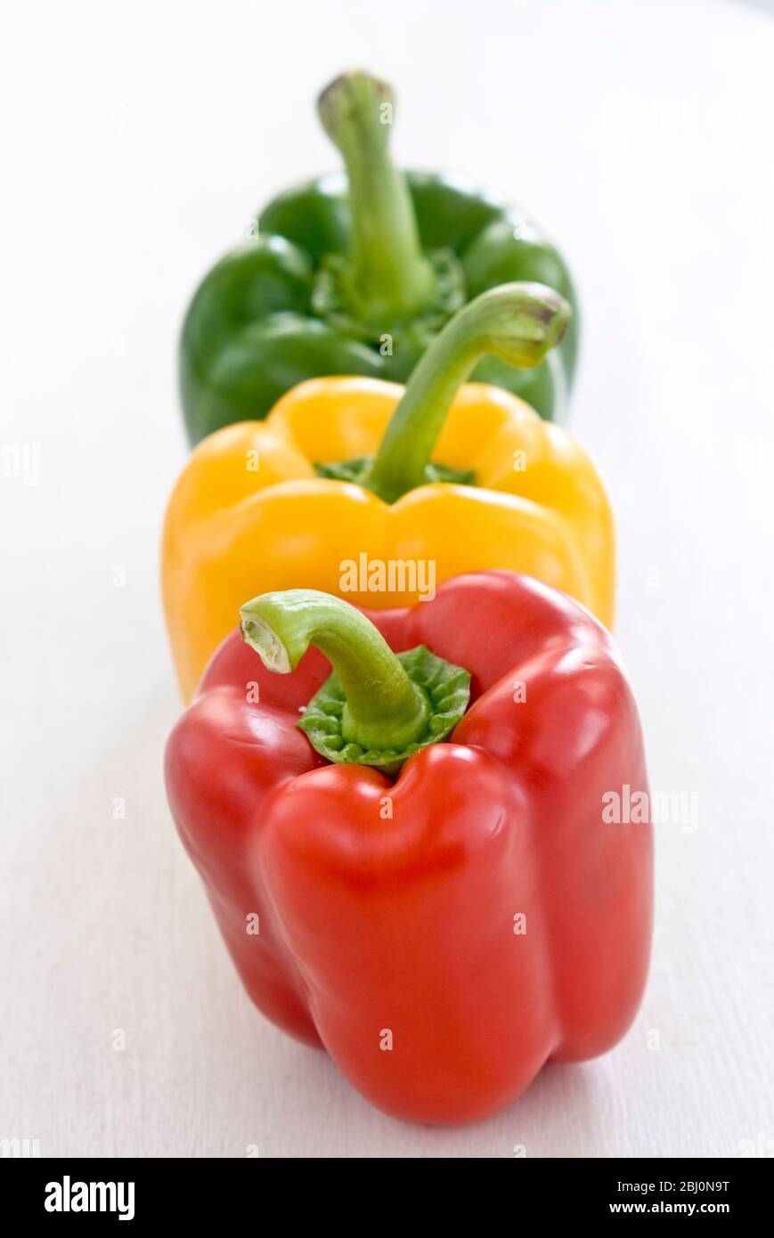 Drei glänzende Paprika, rot, grün und gelb - Stockfoto