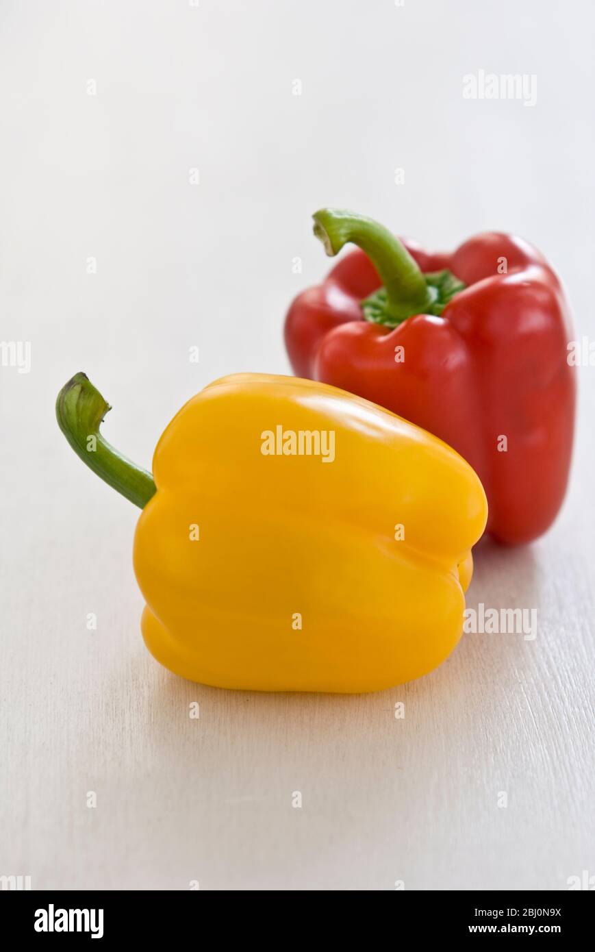 Zwei glänzende Paprika, rot und gelb - Stockfoto