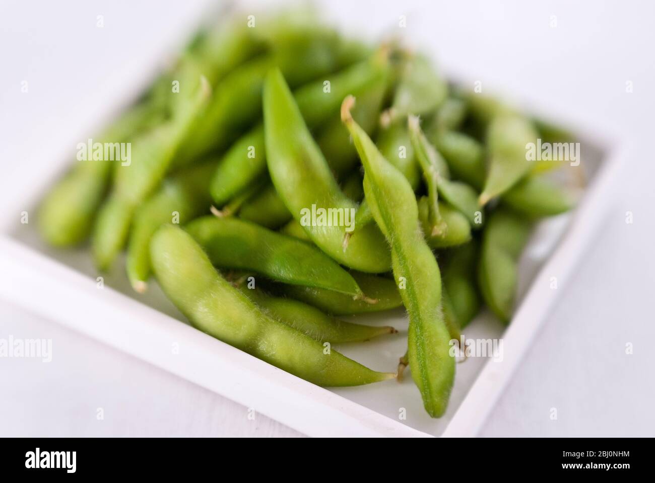 Gekochte Edamambohnen auf kleinen weißen Teller - Stockfoto