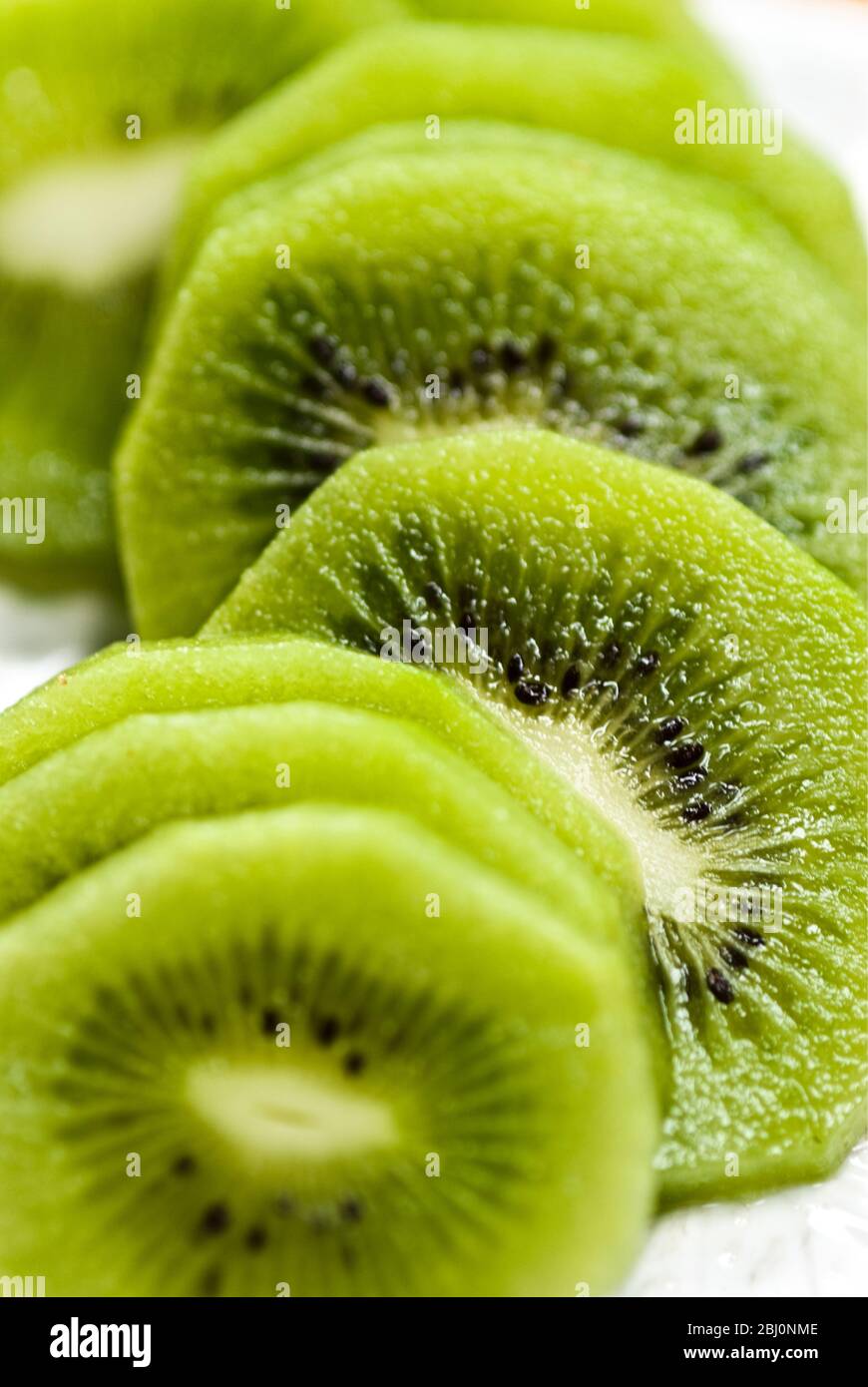 Scheiben geschälte Kiwi-Früchte auf weißem, strukturiertem Teller - Stockfoto