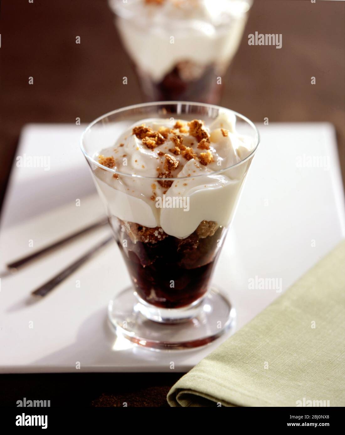 Reichhaltiges Dessert aus Sahne Schokolade und Biskuitkuchen im Glas - Stockfoto