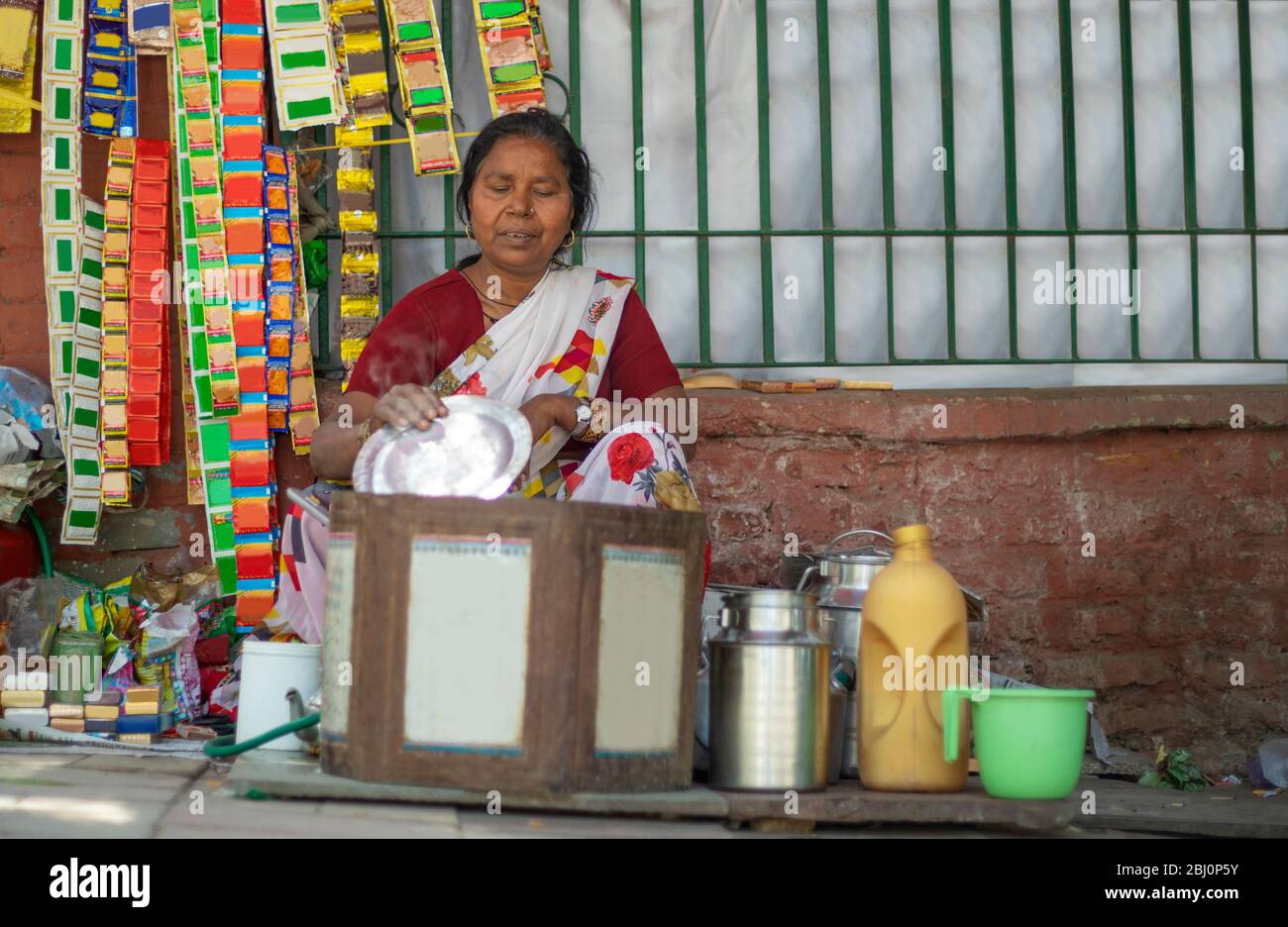 Alte Frau, die Tee auf einem Straßenstand Tee macht. (Gewöhnliche Personen) Stockfoto
