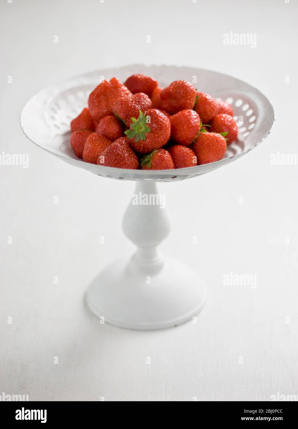 Englische Erdbeeren auf weiß lackiertem Ständer - Stockfoto