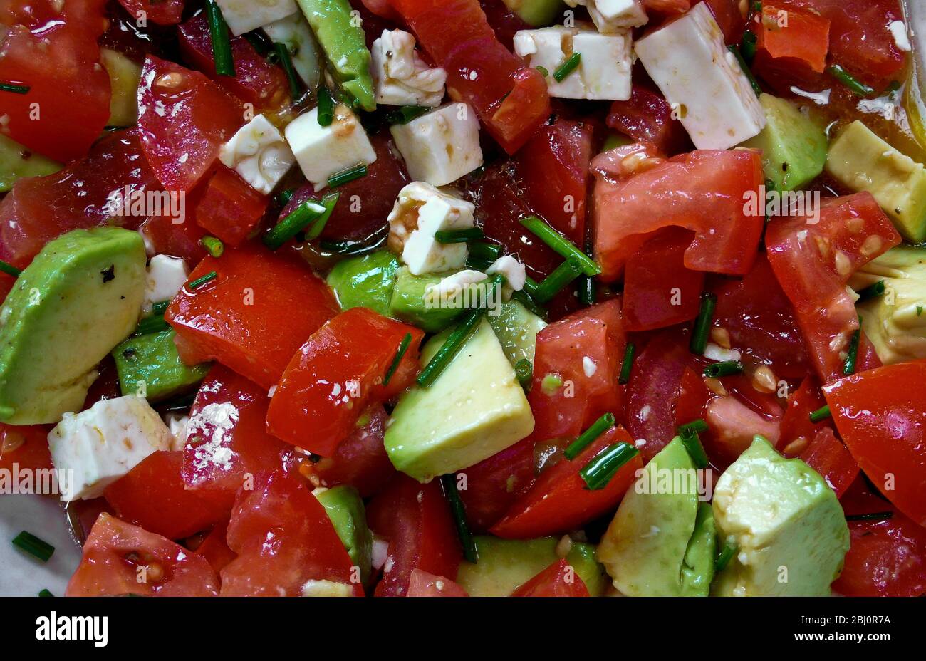 Gesunder Sommersalat aus Avocado, Tomaten und Feta-Käse - Stockfoto