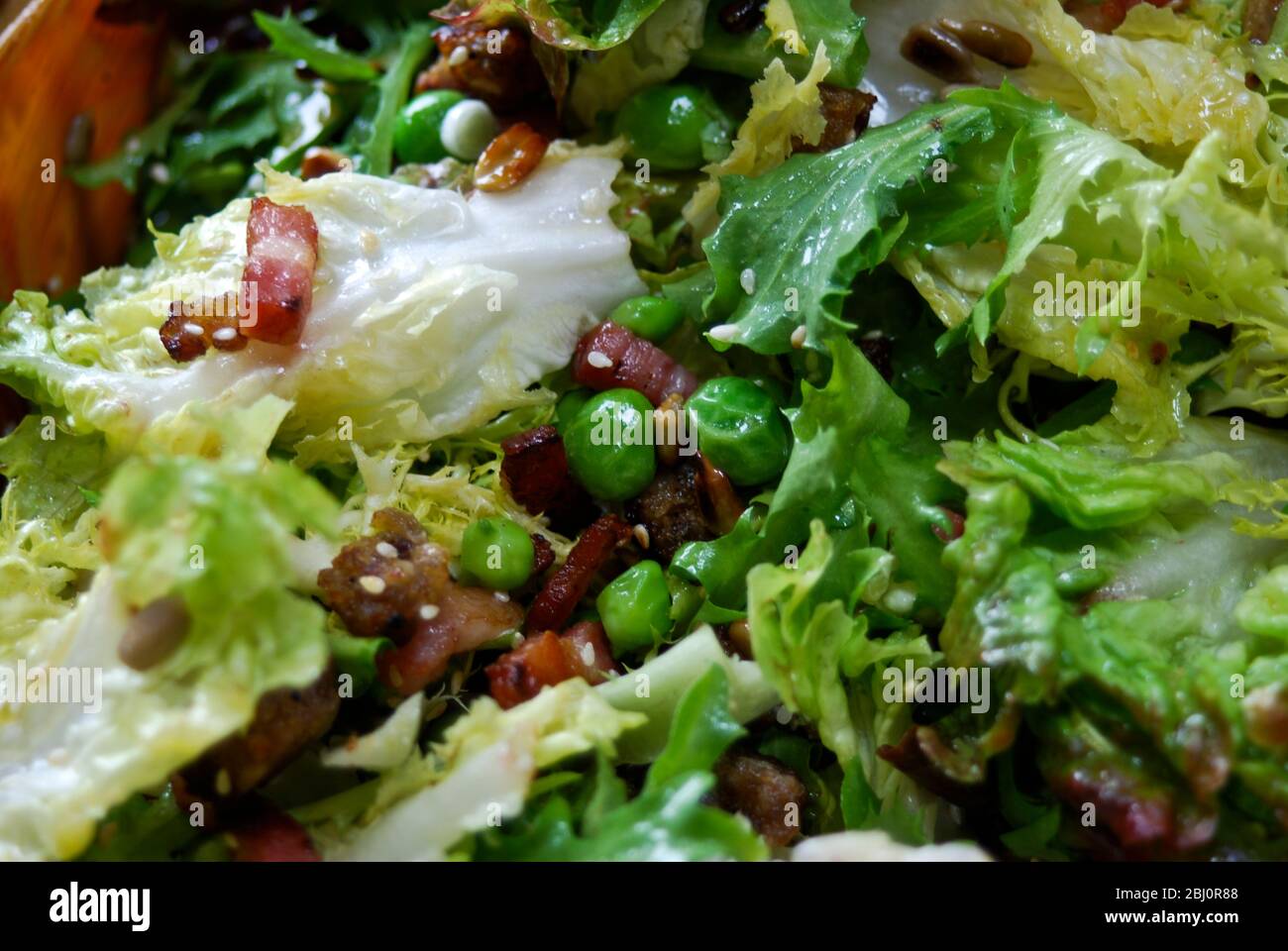 Frischer Sommersalat aus gemischten Blättern, Samen und Körnern, Gartenerbsen und Pfannkuchen - Stockfoto