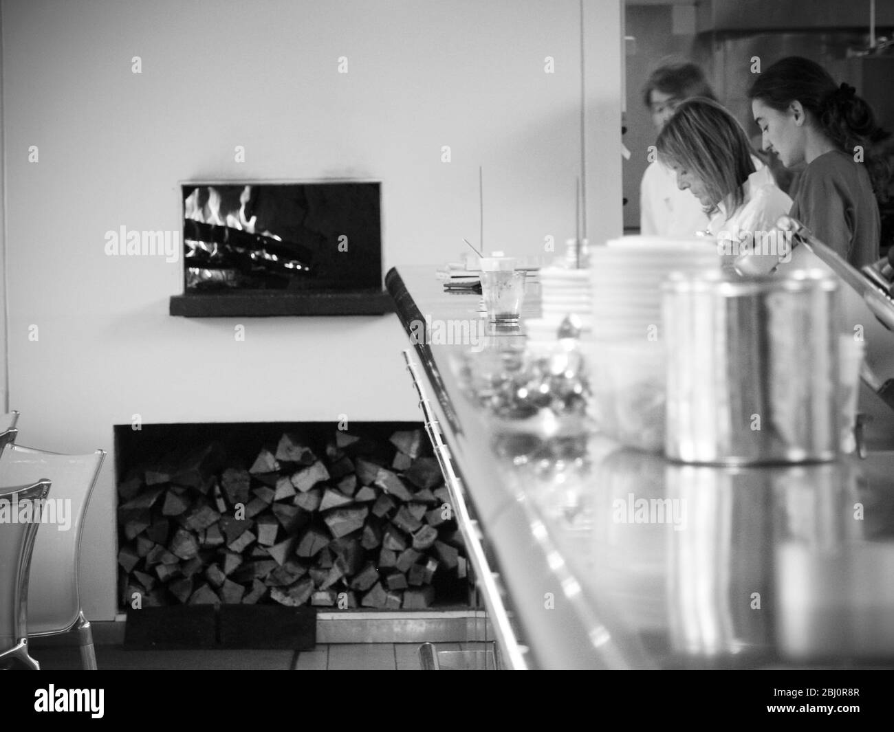 Ruth Rogers und Mitarbeiter des River Cafe Restaurants in London, die Holzfeuer, Holzladen und Edelstahltheke mit gestapeltem Geschirr zeigen - Stockfoto