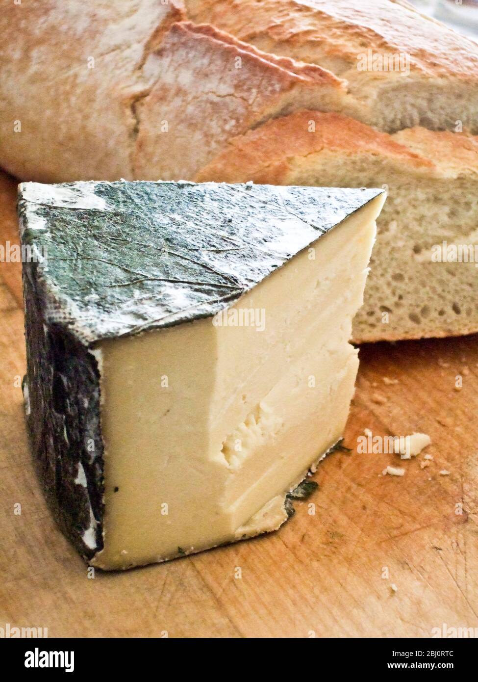 Kornischer Yarg-Käse mit Nesseldeckeln an Bord mit knusprigem Brot. - Stockfoto