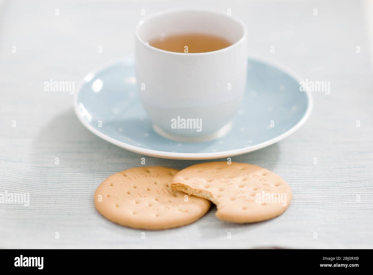 Zwei reichhaltige Teegebäck und eine Tasse grüner Tee als entspannende Pause - Stockfoto