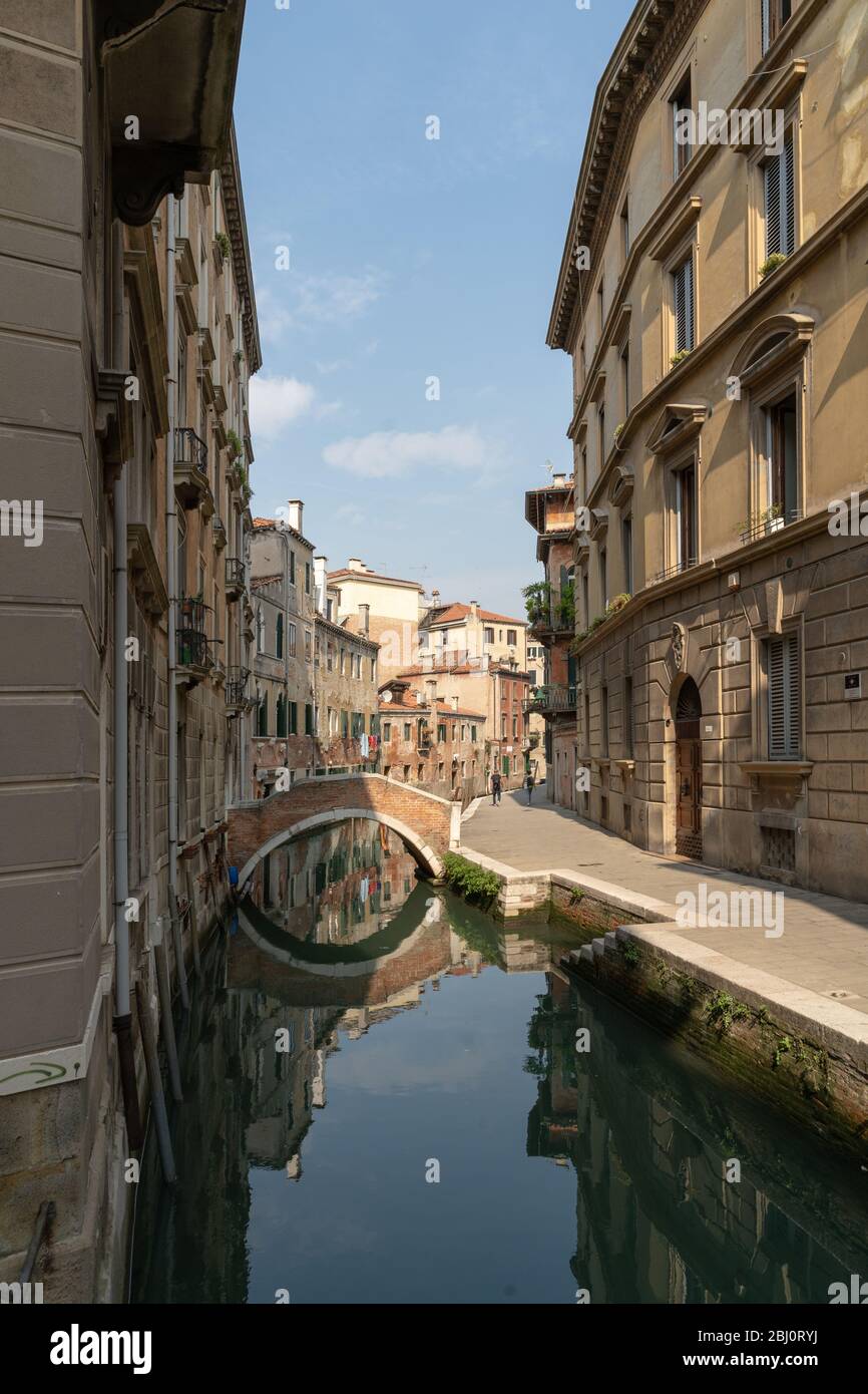 Eine schmale Stadtstraße und ein Kanal mit Gebäuden an der Seite mit schönem Himmel im Hintergrund Stockfoto