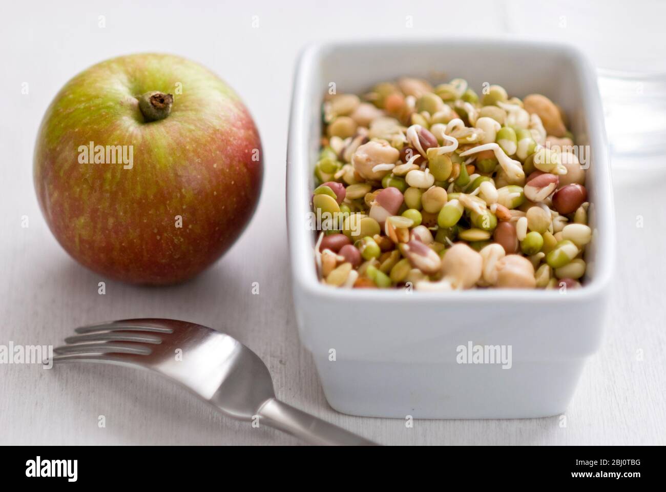 Leichtes Mittagessen mit gemischten Samen und Hülsenfrüchten, gekleidet in Reisessig mit einem Apfel - Stockfoto