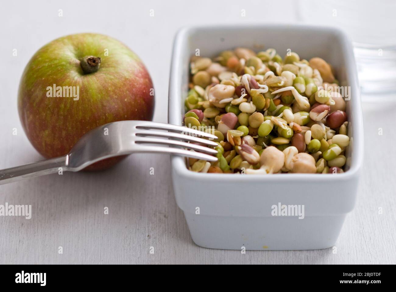 Leichtes Mittagessen mit gemischten Samen und Hülsenfrüchten, gekleidet in Reisessig mit einem Apfel - Stockfoto