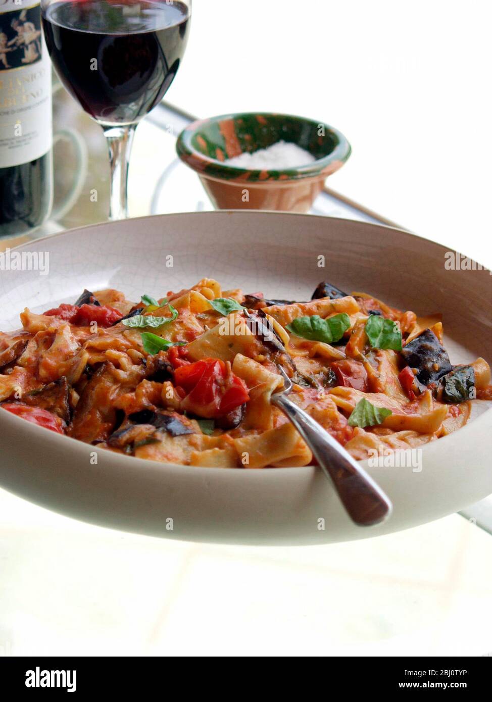 Gericht aus Aubergine und Mozzarella mit Pasta mit Wein auf Glastisch - Stockfoto