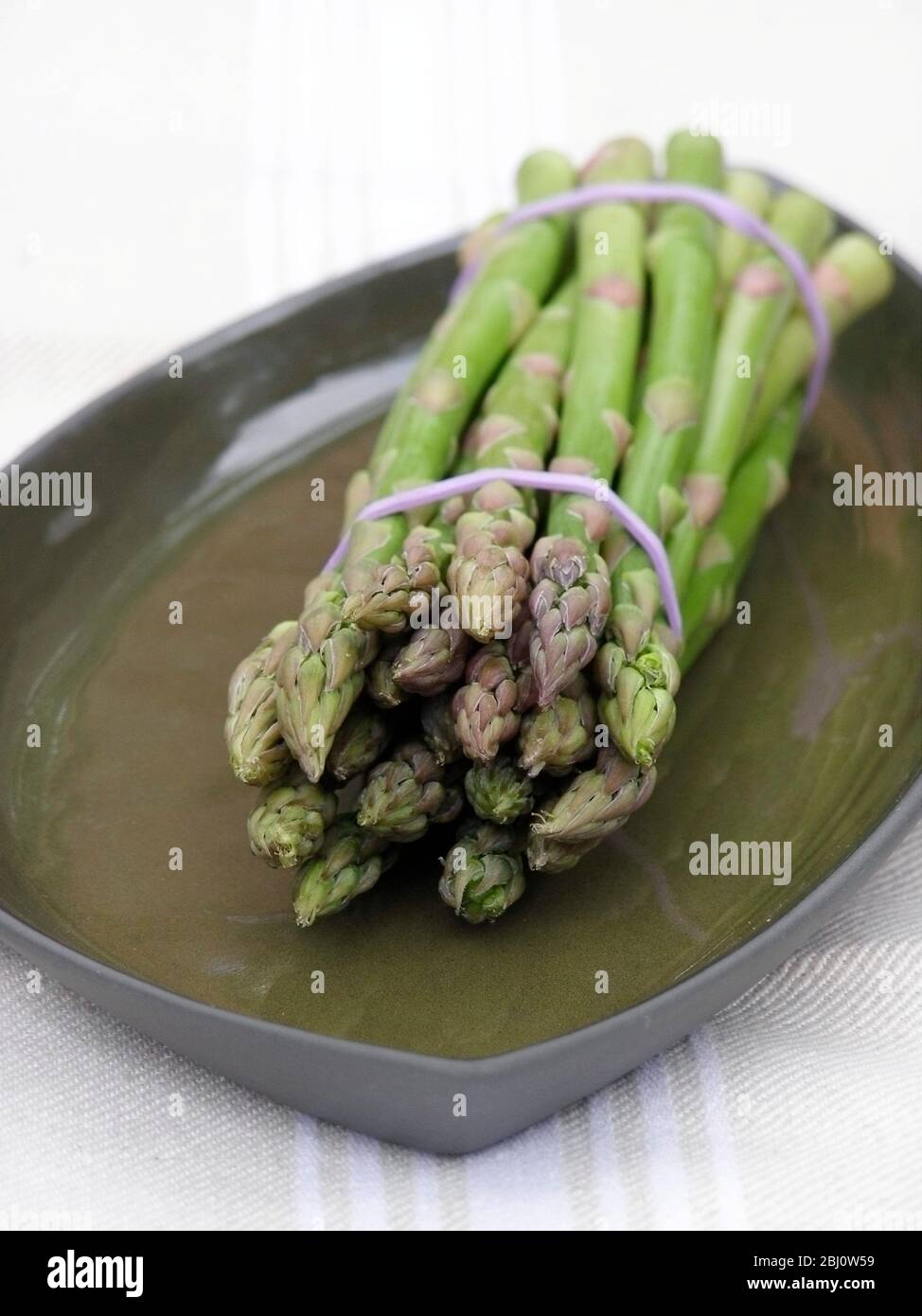 Bund Spargel auf grüner Platte - Stockfoto