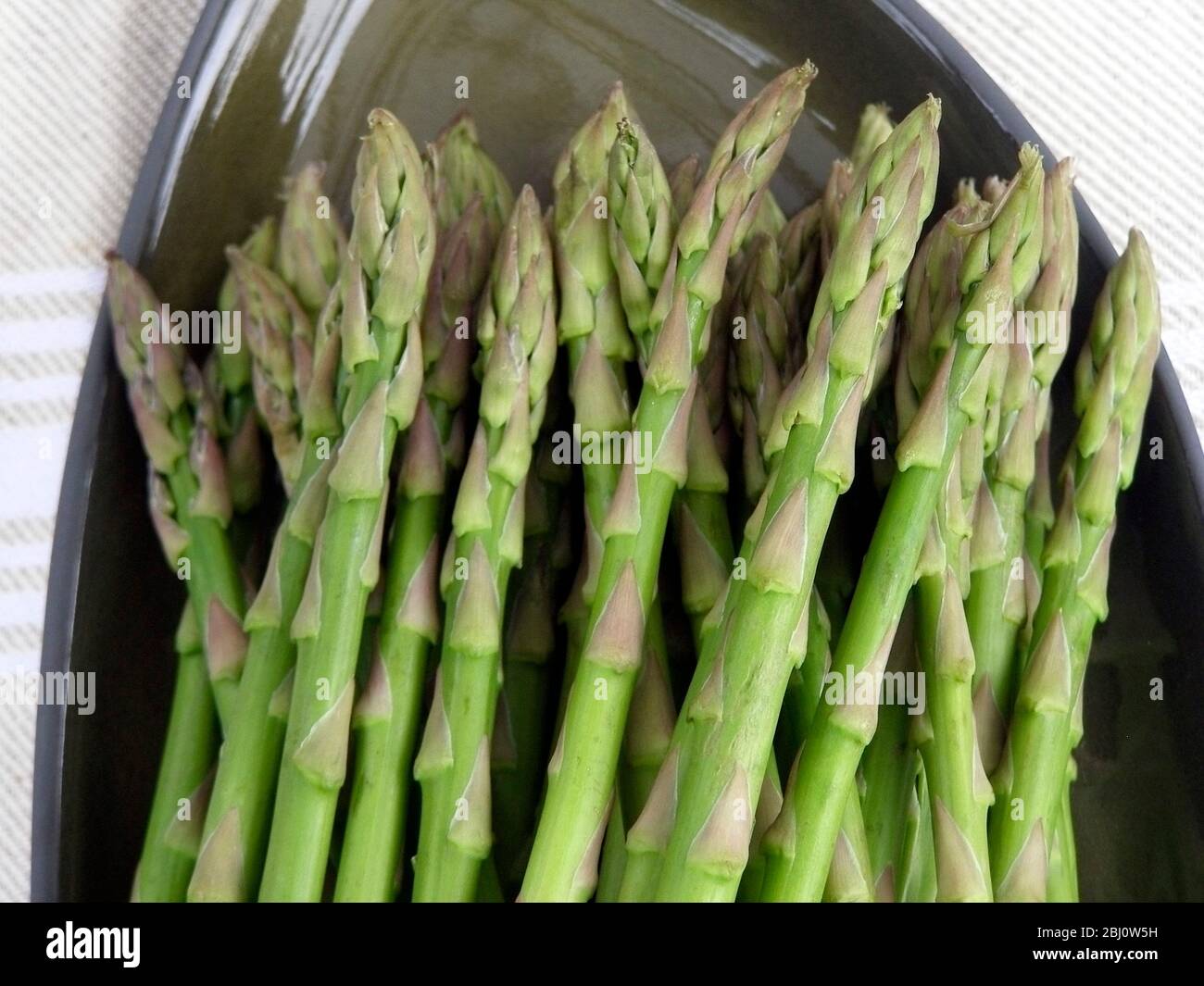 Bund Spargel auf grüner Platte - Stockfoto