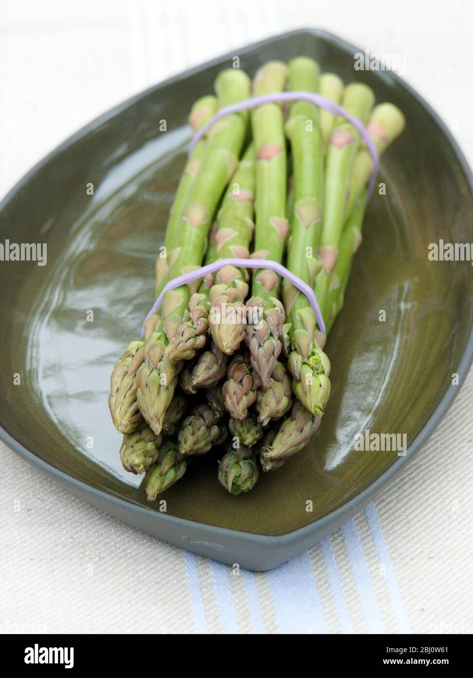 Bund Spargel auf grüner Platte - Stockfoto