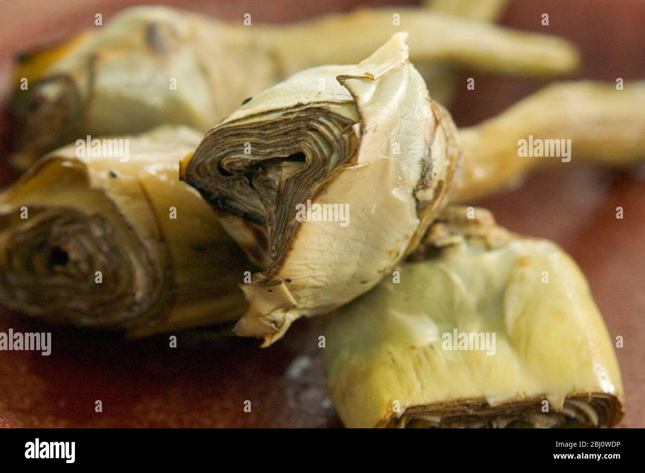 Italienische gegrillte und marinierte Artischocken auf braunem Gericht - Stockfoto
