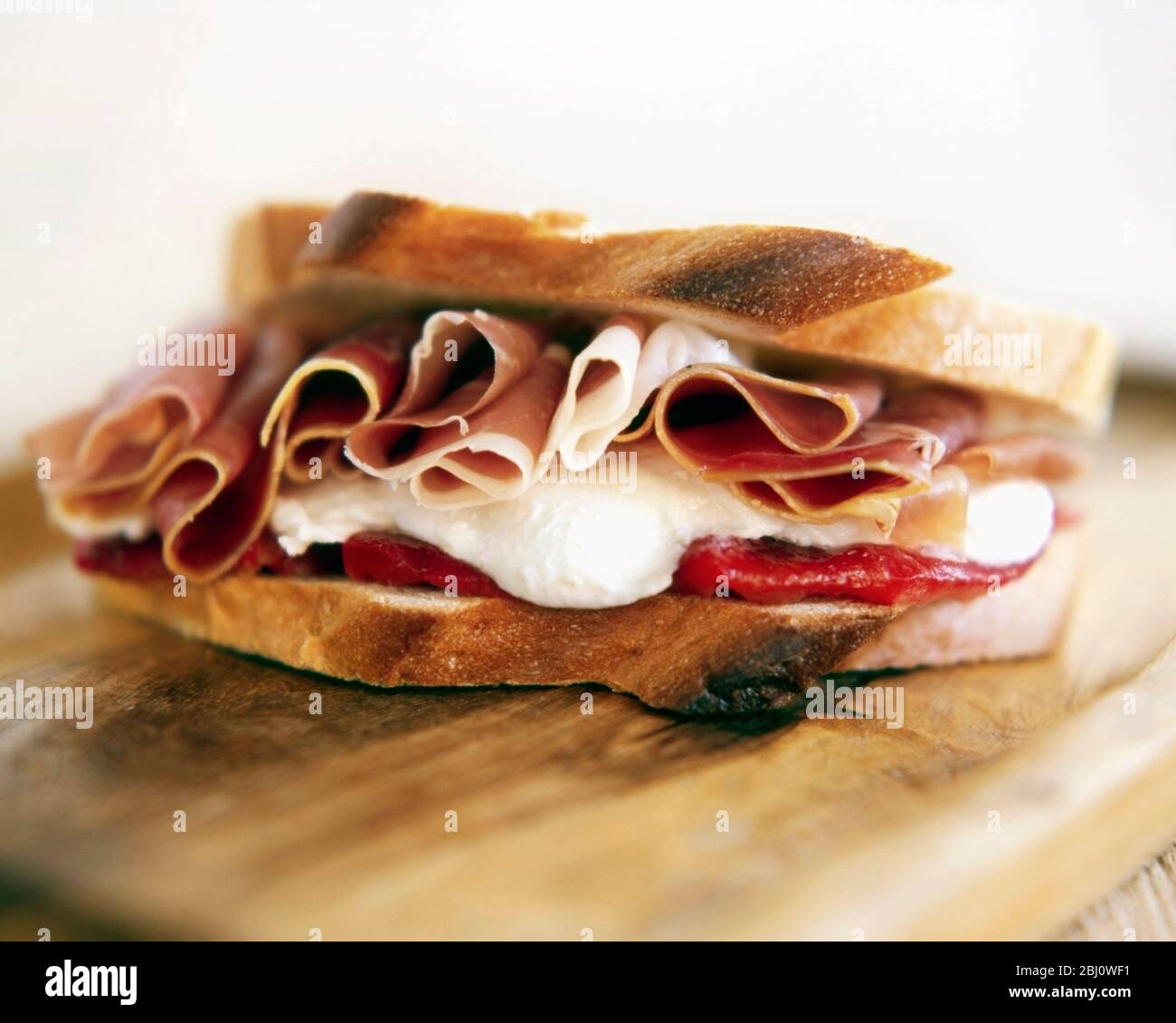Sandwich mit parmaschinken und Mayo auf dem Roggen Brot sitzt auf Holzbrett Stockfoto