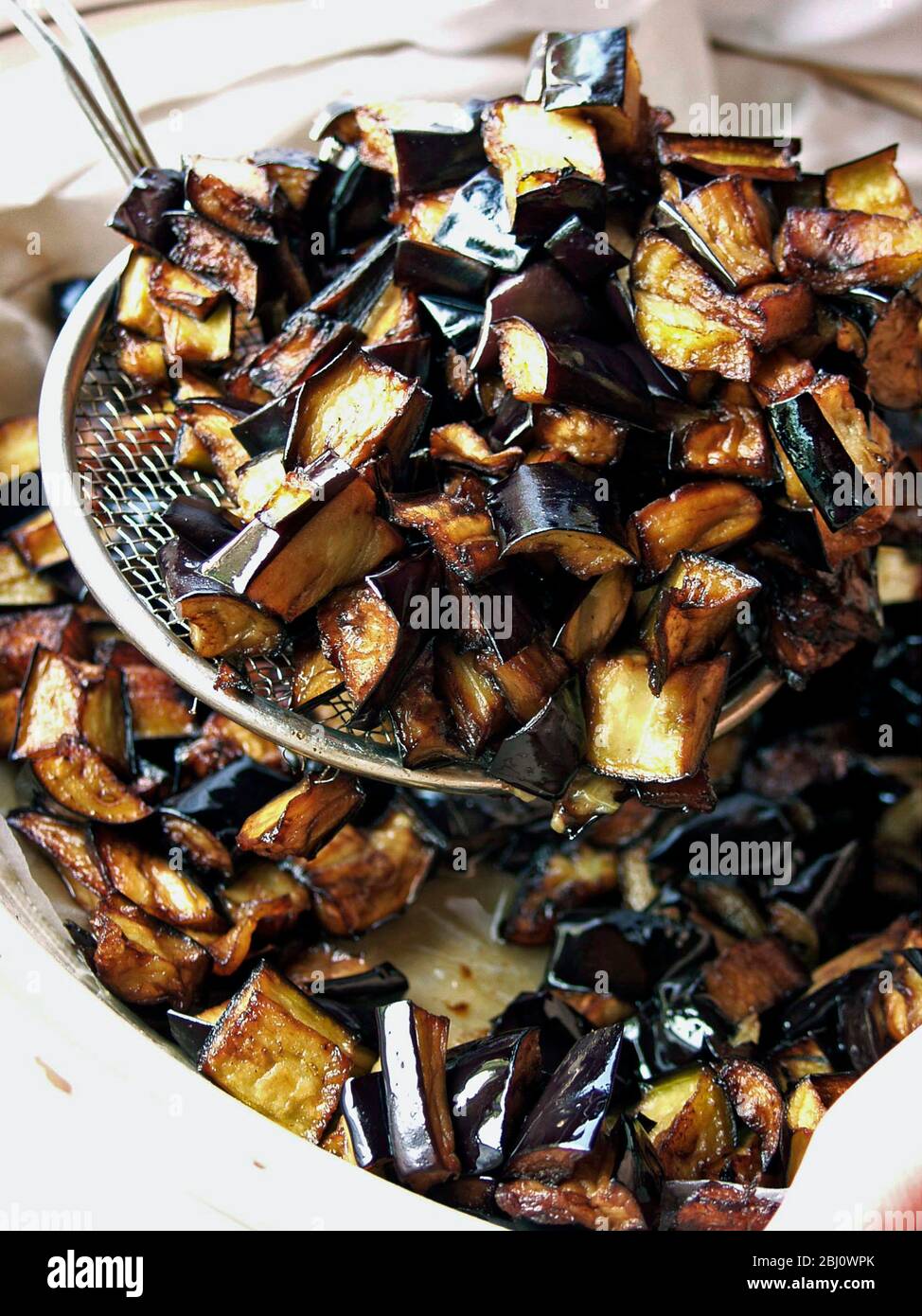 Aubergine, die mit Mehl bestäubt und vor dem Einfüllen in das Geschirr deprittiert wird, um die Ölaufnahme zu minimieren - Stockfoto