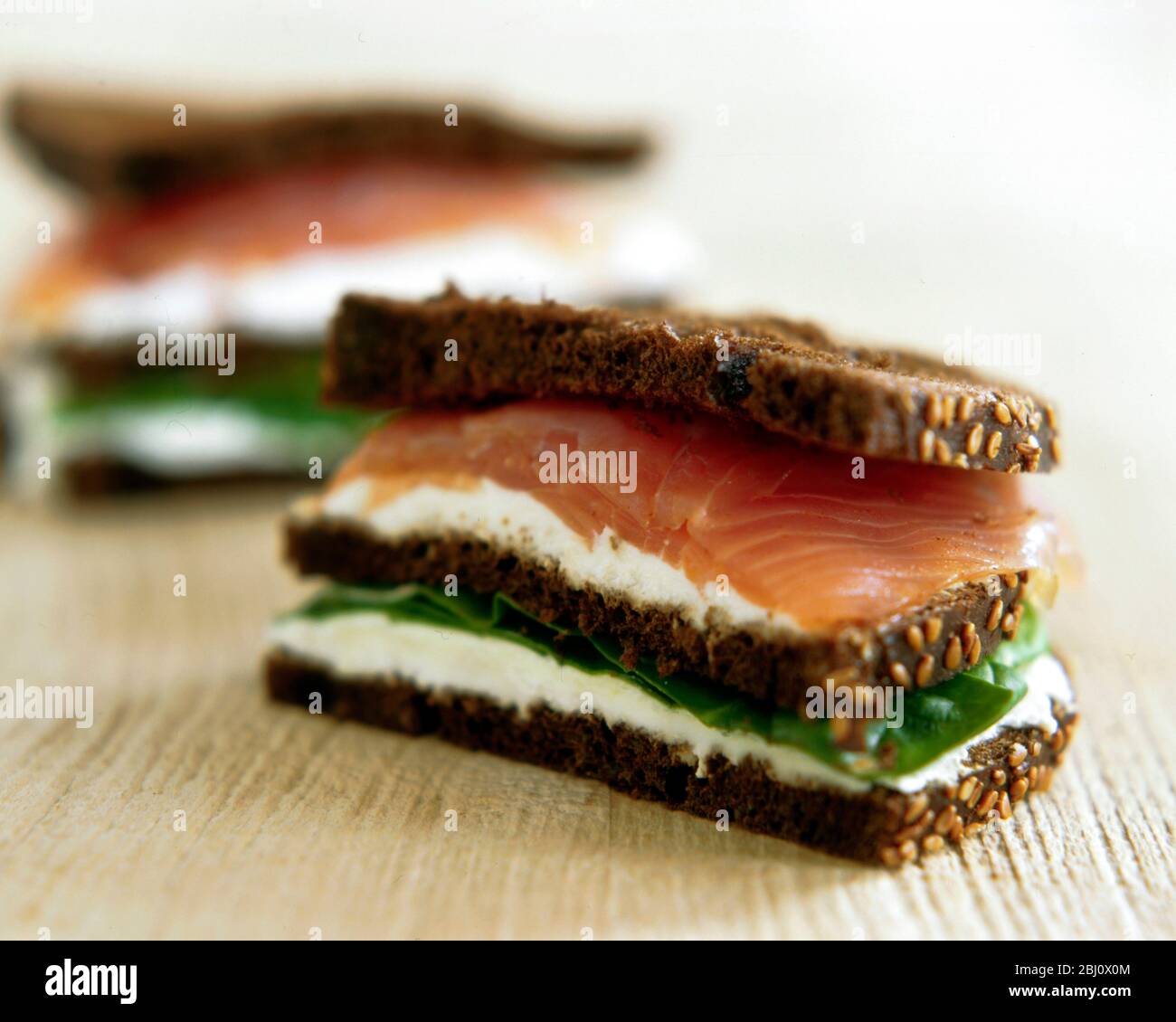 Geräuchertes Lachs- und Frischkäse-Sandwich auf dunklem Roggenbrot - Stockfoto