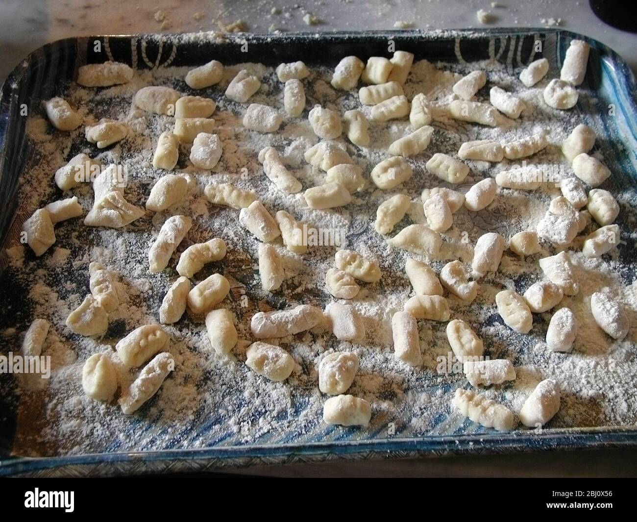 Tablett mit frisch zubereiteten Gnocchi zum Kochen - Stockfoto